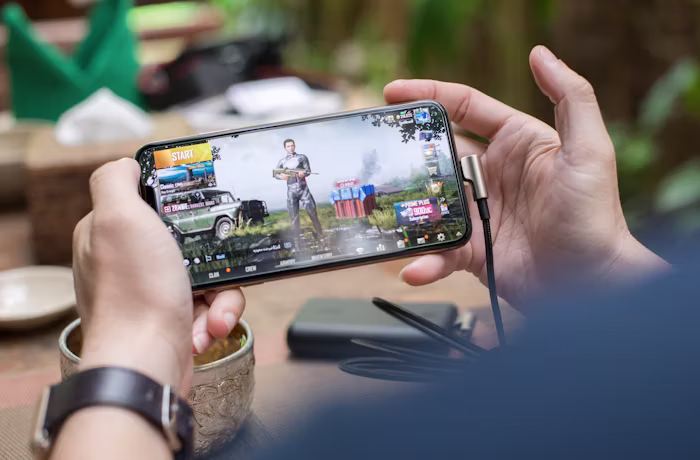 A person playing a high-performance mobile game on a 120Hz smartphone display